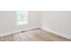Bedroom featuring wood-look flooring, white baseboards, a vent, and a window for natural light at 260 Ellington Rd, Graham, NC 27253