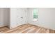 Bedroom featuring wood-look flooring, natural light, and a closet with double doors at 260 Ellington Rd, Graham, NC 27253