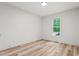 Cozy bedroom with wood-look flooring, natural light from the window, and fresh paint at 260 Ellington Rd, Graham, NC 27253