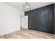 Bedroom with wood-look floors, a modern light fixture, and a decorative black accent wall at 260 Ellington Rd, Graham, NC 27253