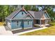 Stylish blue house with red accents and black mulch, showcasing a well-maintained lawn and modern design at 260 Ellington Rd, Graham, NC 27253