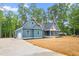 Charming blue two-story home with landscaped yard and a concrete driveway leading to an attached garage at 260 Ellington Rd, Graham, NC 27253