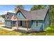 Eye-catching blue home with red support beams, a covered front porch, and tidy landscaping for curb appeal at 260 Ellington Rd, Graham, NC 27253