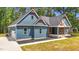 Attractive blue house with a well-manicured lawn and a driveway leading to an attached garage on the side at 260 Ellington Rd, Graham, NC 27253