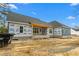 New home construction showing brick foundation, blue siding, and large windows against a bright sky at 260 Ellington Rd, Graham, NC 27253