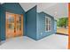 Covered front porch with blue siding showcases a stylish double wood and glass front door at 260 Ellington Rd, Graham, NC 27253