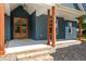 Inviting front porch with wooden columns, brick base, and stylish front door at 260 Ellington Rd, Graham, NC 27253