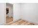 Bright hallway featuring wood-look flooring, white walls, and an open doorway to another room at 260 Ellington Rd, Graham, NC 27253