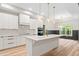 Bright kitchen featuring white cabinets, modern appliances, and a large central island with quartz countertop and gold pendant lights at 260 Ellington Rd, Graham, NC 27253