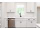 Close-up on a kitchen sink with white cabinets and a stainless steel dishwasher at 260 Ellington Rd, Graham, NC 27253