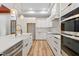 Bright kitchen featuring white cabinets, modern appliances, a large central island with quartz countertop and gold fixtures at 260 Ellington Rd, Graham, NC 27253
