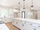 Contemporary kitchen design with white cabinets, subway tile backsplash and an expansive island at 260 Ellington Rd, Graham, NC 27253