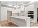 Bright kitchen featuring white cabinets, modern appliances, and a large central island with quartz countertop and gold fixtures at 260 Ellington Rd, Graham, NC 27253