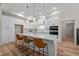 Modern white kitchen featuring an island with bar seating, pendant lighting, and stainless steel appliances at 260 Ellington Rd, Graham, NC 27253