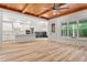 Open living space with wood ceiling flows into a white kitchen featuring a center island and a modern lighting fixtures at 260 Ellington Rd, Graham, NC 27253