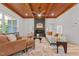 Bright living room boasts wood-paneled ceilings, a modern fireplace, and neutral-toned furniture with orange accents at 260 Ellington Rd, Graham, NC 27253