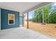 Covered patio features sturdy wood posts and ample space overlooking the natural landscape of this newly built home at 260 Ellington Rd, Graham, NC 27253