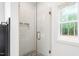 Close-up of glass shower with tile surround and river rock floor at 260 Ellington Rd, Graham, NC 27253
