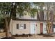 Beige townhouse with a white front door and landscaping at 3 Patriot Cir, Durham, NC 27704