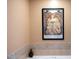 The neutral-toned bathroom features a framed Alphonse Mucha art print and tiled bathtub at 317 W Morgan Street # 405, Raleigh, NC 27601