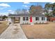 Front view of a renovated ranch home with gray brick and a red door at 322 Pace St, Smithfield, NC 27577