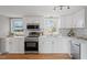Modern kitchen featuring white cabinets, stainless steel appliances, and quartz countertops at 322 Pace St, Smithfield, NC 27577