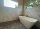 Elegant bathroom featuring a soaking tub, marble-look tile, and modern fixtures at 324 Waldo St, Cary, NC 27511
