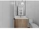 Bathroom vanity with a marble countertop, modern light fixture, and decorative mirror at 324 Waldo St, Cary, NC 27511