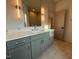 Bathroom with dual sinks, gray cabinets, and quartz countertops at 324 Waldo St, Cary, NC 27511