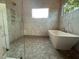 Modern bathroom with glass enclosed shower, soaking tub, and beautiful marble-look tile at 324 Waldo St, Cary, NC 27511