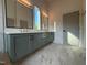 Bathroom with dual sinks, gray cabinets, marble floors, and modern lighting at 324 Waldo St, Cary, NC 27511
