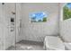 Spa-like bathroom boasts marble walls, a glass-enclosed shower, and a freestanding soaking tub at 324 Waldo St, Cary, NC 27511