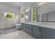 A Luxurious bathroom features dual vanities, soaking tub, and marble tile at 324 Waldo St, Cary, NC 27511