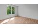 Bright bedroom with hardwood floors and a large window providing natural light at 324 Waldo St, Cary, NC 27511