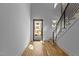 Modern entryway with hardwood floors, white walls, black framed glass door and staircase with black rails at 324 Waldo St, Cary, NC 27511