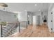 Hallway with hardwood floors, modern railing, and view of staircase at 324 Waldo St, Cary, NC 27511