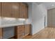 Hallway with built in bar, wooden cabinets, white countertop and hardwood floors at 324 Waldo St, Cary, NC 27511