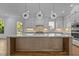 Spacious kitchen island with elegant lighting, sink, seating, white cabinets, and stainless appliances at 324 Waldo St, Cary, NC 27511