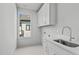 Bright laundry room featuring sleek white cabinetry, countertop, and a window for natural light at 324 Waldo St, Cary, NC 27511