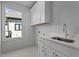 Laundry room featuring white cabinetry, a window, and modern sink and faucet at 324 Waldo St, Cary, NC 27511