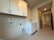 Well-lit laundry room with white cabinets, sink, and washer/dryer hookups for convenience at 324 Waldo St, Cary, NC 27511