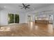 Open-concept living room with hardwood floors, ceiling fan, and view into kitchen at 324 Waldo St, Cary, NC 27511
