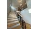 Bright open staircase featuring modern railings, hardwood steps, and a stylish light fixture at 324 Waldo St, Cary, NC 27511