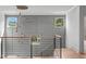 Staircase with sleek metal railings, wood steps, wainscotting, and modern chandelier at 324 Waldo St, Cary, NC 27511