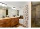Bathroom featuring double sinks, tiled walls, soaking tub with a decorative shower curtain, and a glass shower at 3413 Thistledown Ct, Efland, NC 27243