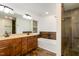Bathroom with a large mirror, double sinks, tiled walls, soaking tub, and a glass shower at 3413 Thistledown Ct, Efland, NC 27243