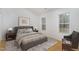 Bedroom featuring a bed, wood floors, two windows, and a sitting area with an upholstered chair at 3413 Thistledown Ct, Efland, NC 27243