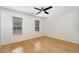 Bedroom with hardwood floors, white walls, ceiling fan, and natural light from two windows at 3413 Thistledown Ct, Efland, NC 27243