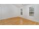 Neutral bedroom with hardwood floors, white walls, and natural light from two windows at 3413 Thistledown Ct, Efland, NC 27243