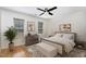 Bedroom featuring a bed, wood floors, dresser, two windows, and a ceiling fan at 3413 Thistledown Ct, Efland, NC 27243